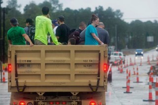 Members of the Louisiana Army National Guard rescue people from rising floodwater near Walker, La., after heavy rains inundated the region, Sunday, Aug. 14, 2016. (AP Photo/Max Becherer)