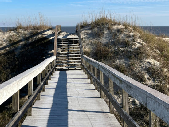 A sand covered boardwalk over the dunes to the Atlantic ocean on Jekyll Island, Georgia