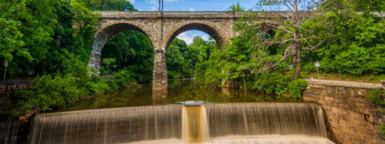 A dam on Wissahickon Creek and old railroad bridge, in Philadelphia, Pennsylvania-Shutterstock_650478007
