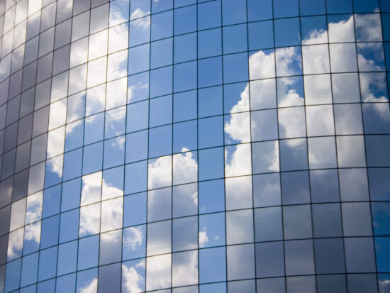 Futuristic abstract business background with reflected blue skies and clouds
